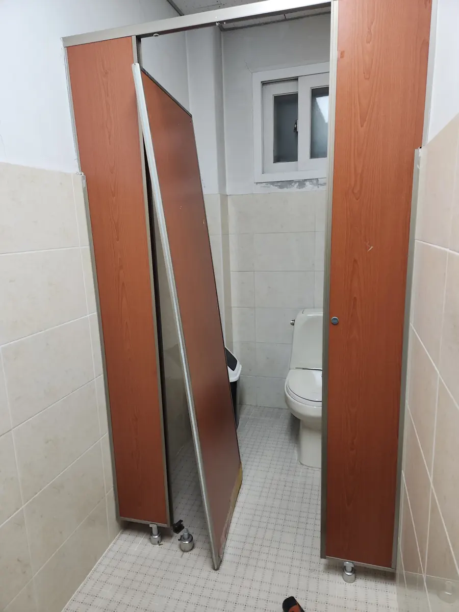 화장실칸막이떨어진문수리 문짝이 기울어져 벽에 기댄 화장실 칸막이 떨어진 문 수리 현장
